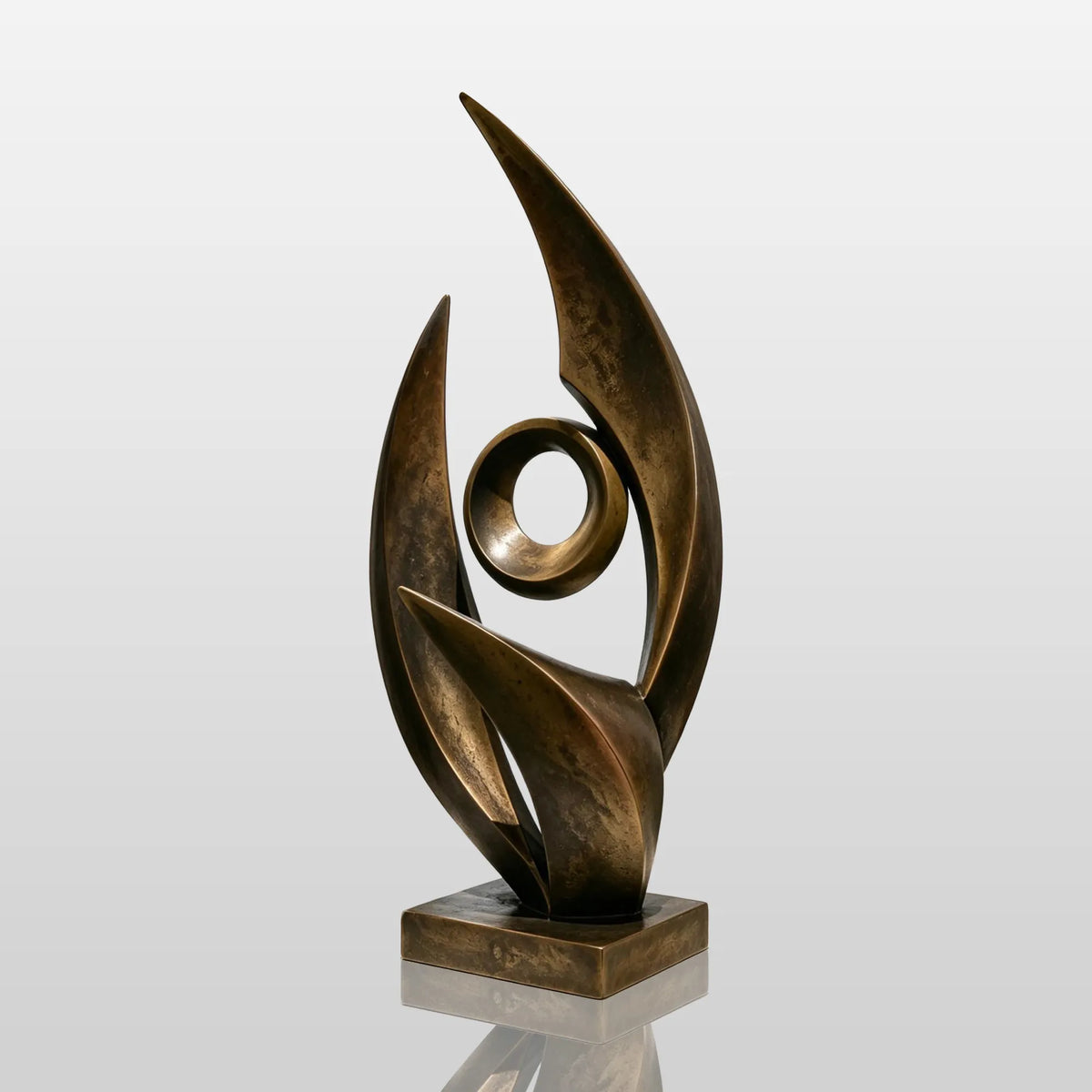 An abstract bronze sculpture rests on a white pedestal inside an art gallery.