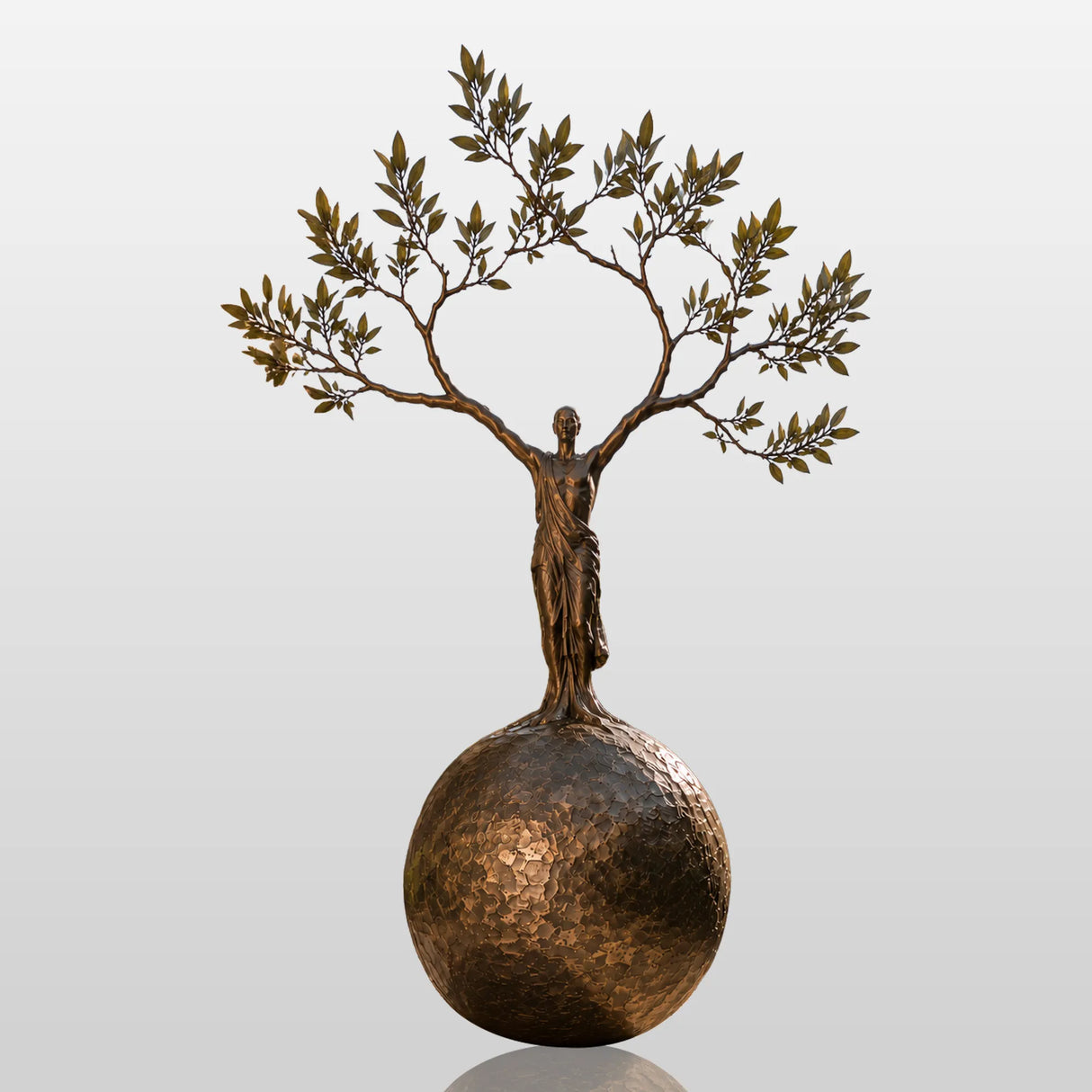 Bronze sculpture with the design of human shaped tree ball stands in a cobblestone courtyard.
