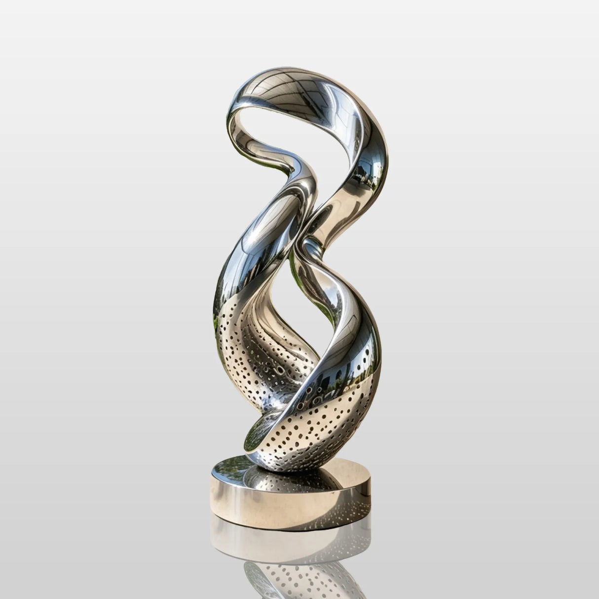Stainless steel twisted loop sculpture stands on the outdoor patio beside a modern building.
