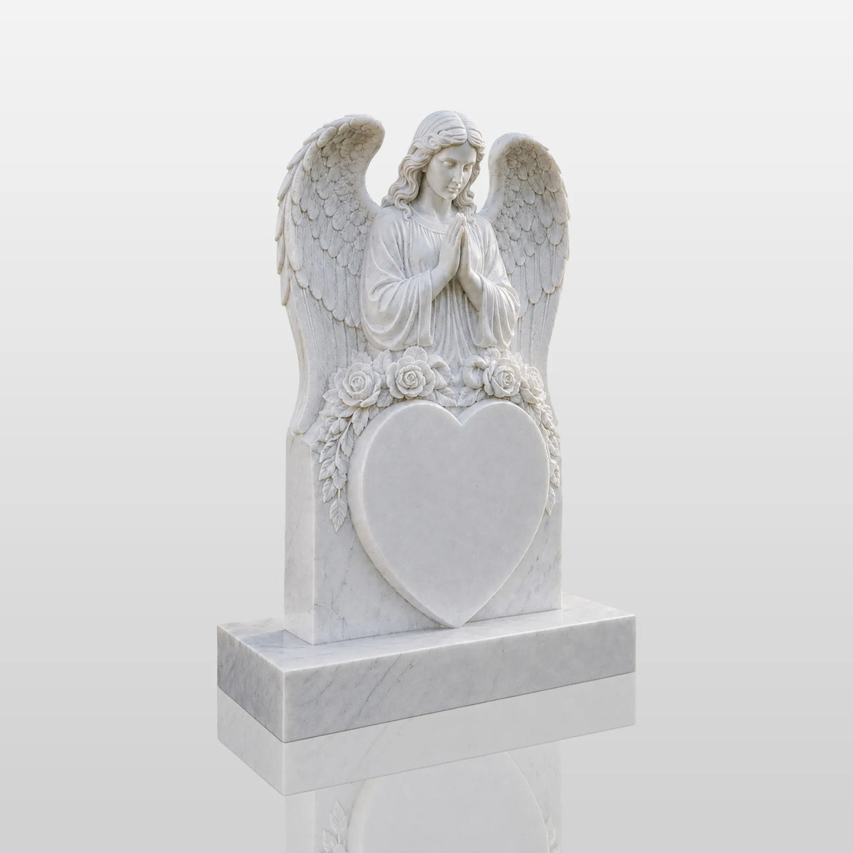 Marble tombstone carved with praying angel, roses and heart stands on the lush green cemetery lawn.