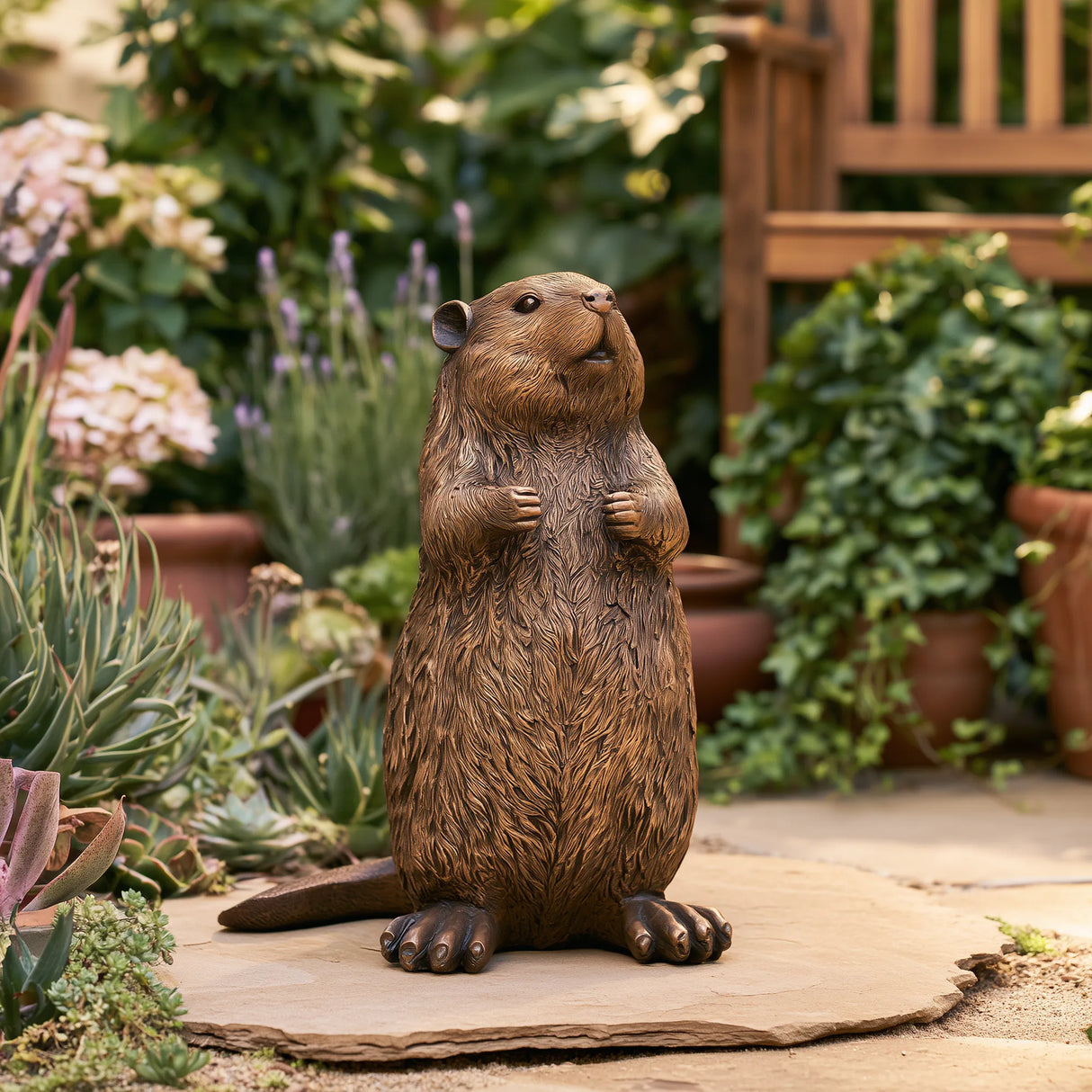 A cute bronze beaver statue stands on the yard surrounded by lush garden plants.