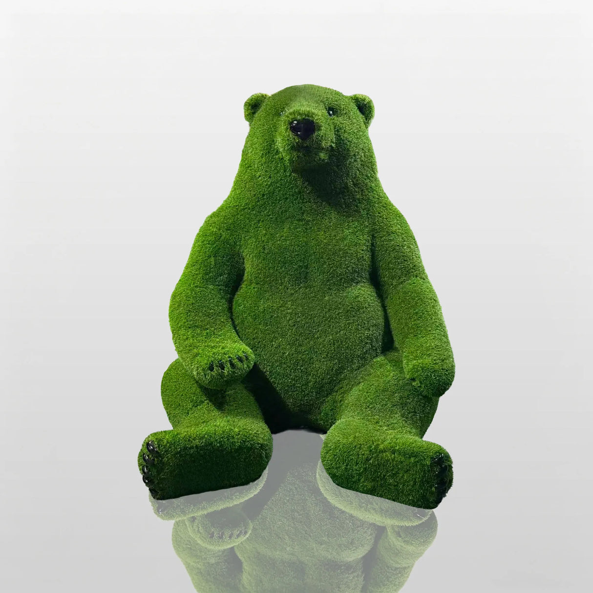 Green fiberglass bear statue sits on a concrete plinth outside the modern building.