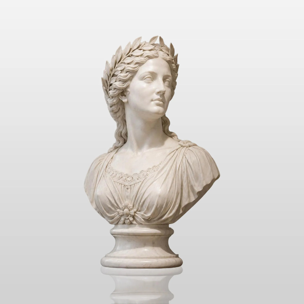A white classical marble bust statue sits on a dark wooden sideboard beside stacked books and small potted greenery in a soft lit interior room.