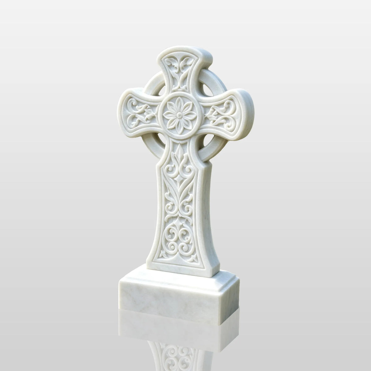 A white marble Celtic cross headstone rests on gravel among green plants.