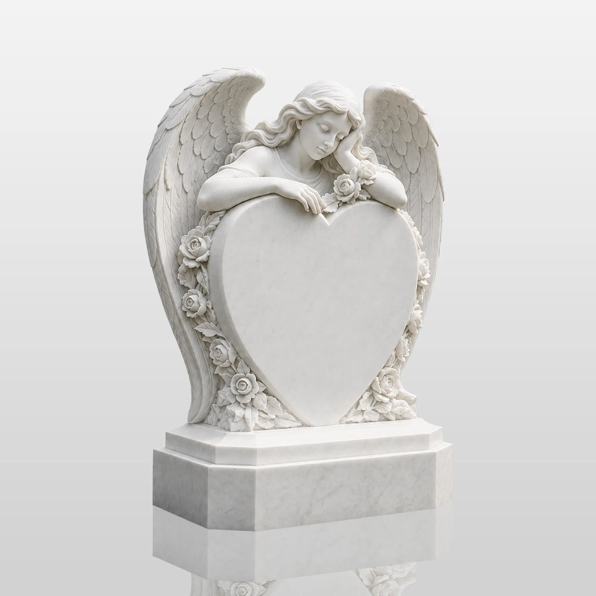 White marble tombstone carved with angel, roses and central blank heart stands on the black gravel cemetery ground.