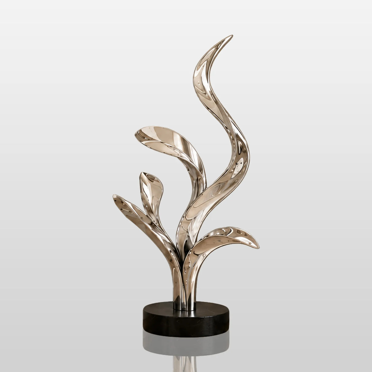 Polished stainless steel abstract leaf sculpture stands in an indoor home corner.