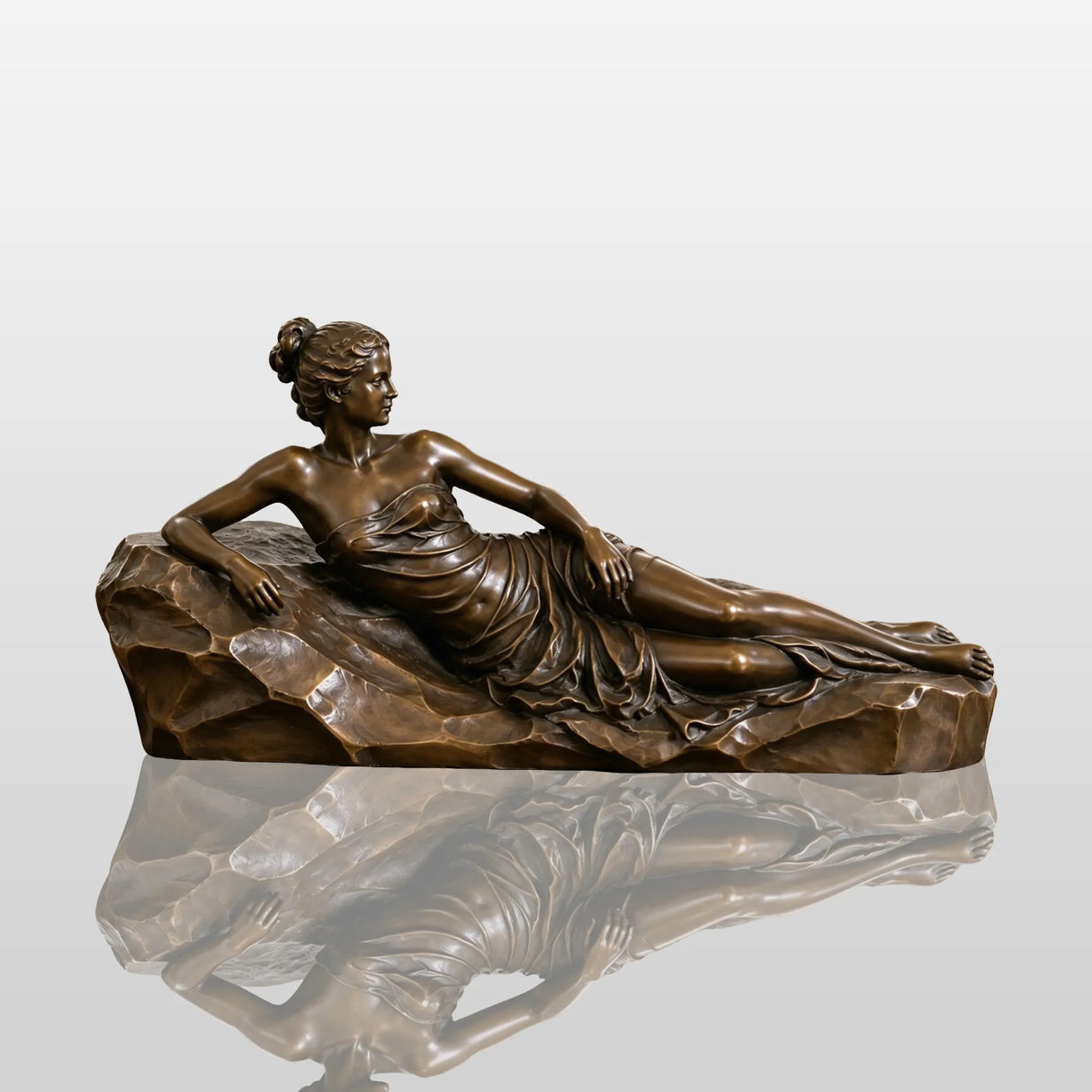 Bronze reclining woman sculpture rests on the wooden cabinet inside a classic home.