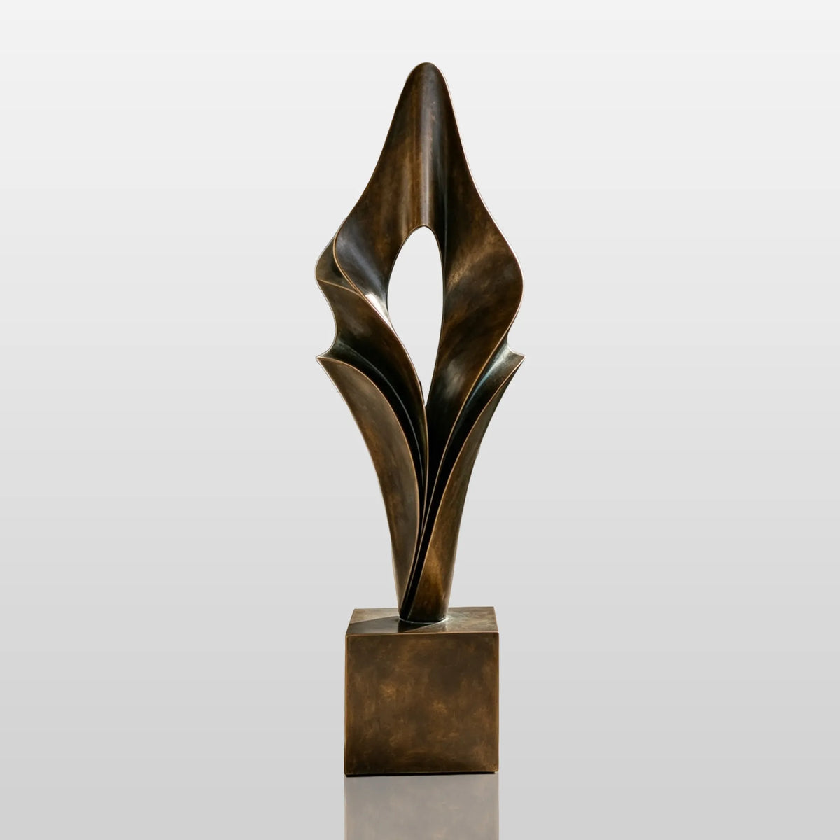 An abstract folded bronze sculpture stands on the entry walkway of a modern home.