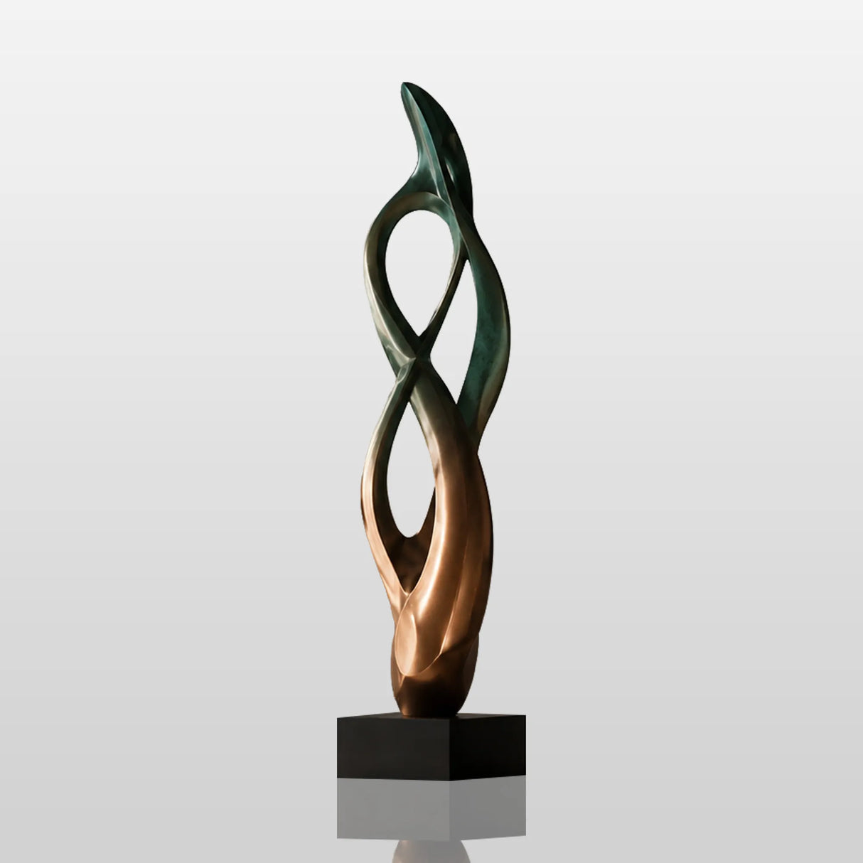 Abstract bronze table sculpture sits on the wooden table beside stacked books.
