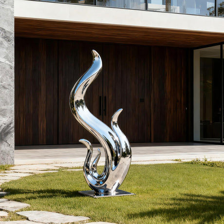 Abstract stainless steel flame sculpture with fluid wave like curves and a polished mirror finish displayed in a modern villa garden.