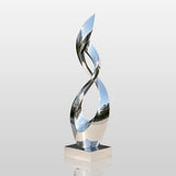 Mirror polished stainless steel twisted sculpture stands by a modern building.