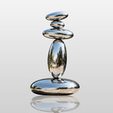 Abstract stainless steel stacked pebble sculpture with polished mirror finish placed for modern courtyard gardens.