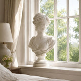 Marble blindfolded lady bust stands on a bright bedroom windowsill.