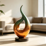A gradient bronze curve sculpture sits on a light table in a living room.