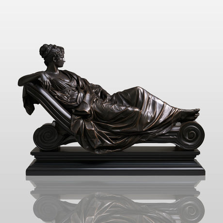 Bronze reclining lady sculpture rests on marble mantel inside elegant classic room.
