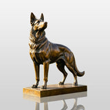 Bronze German shepherd dog statue stands on green grass in front of a residential house.