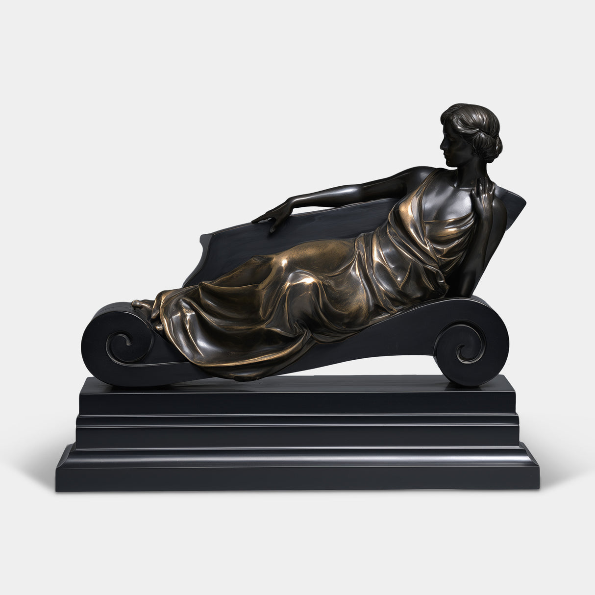 Bronze table top sculpture depicts an elegant lady leaning back on scroll chaise lounge with tiered base.