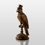 Antique bronze parrot sculpture rests on a study desk beside stacked books and open reading volume.