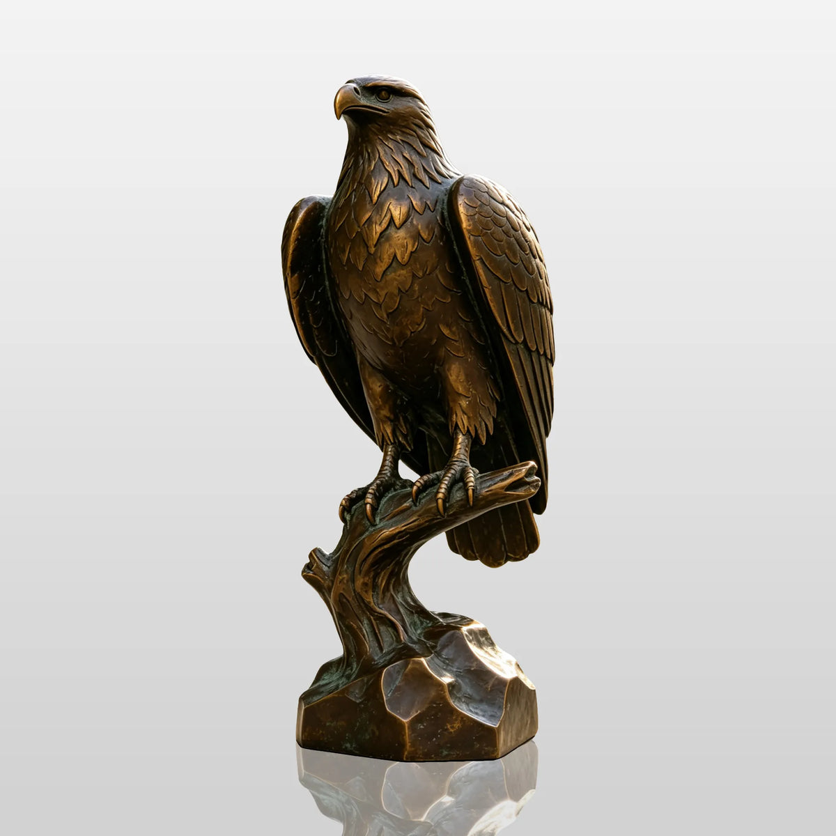 A realistic bronze eagle statue perches on a pedestal in a sunny public park.