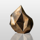Abstract golden bronze sculpture with rock-like irregular form and gradient surface, ideal for modern outdoor or interior art spaces.