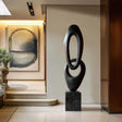 Flowing oval-shaped bronze sculpture with black finish
