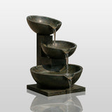 Three tier bronze bowl fountain sits outdoors with water flowing down each bowl.