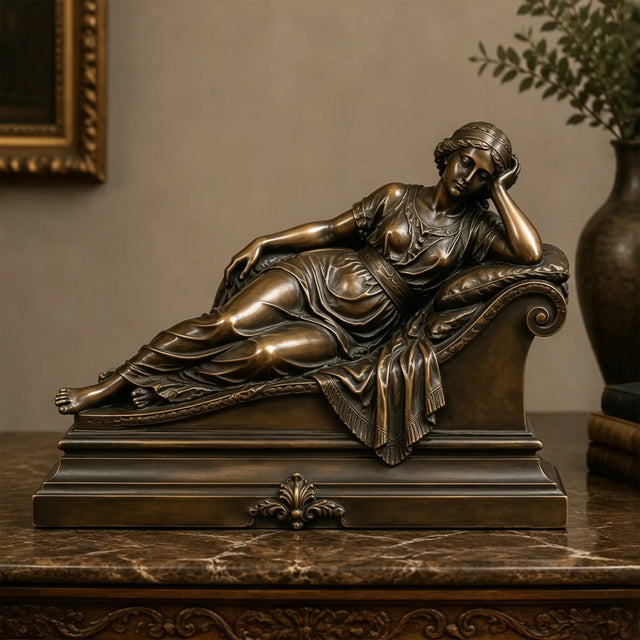 A bronze reclining lady sculpture rests on the marble tabletop.