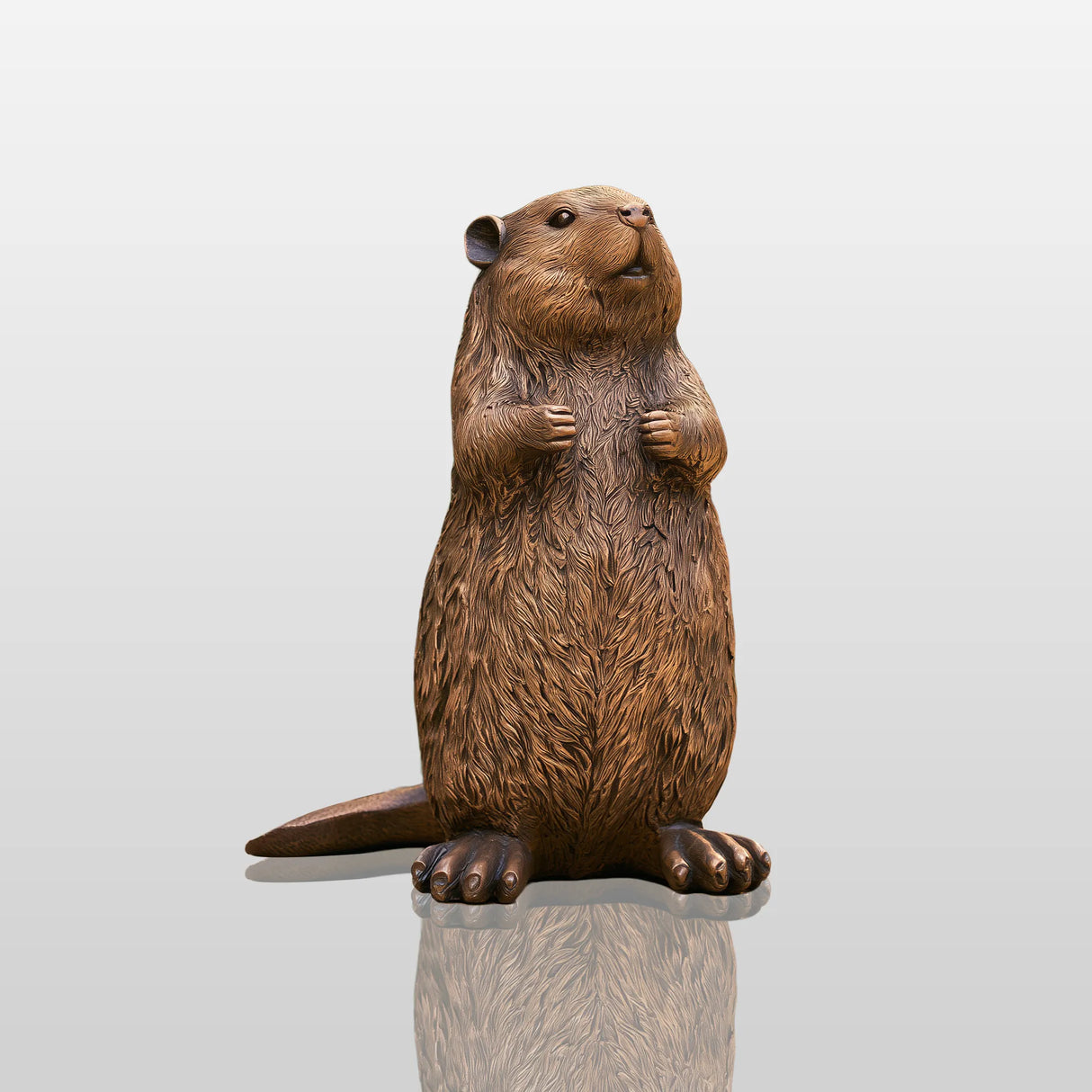 A cute bronze beaver statue stands on the yard surrounded by lush garden plants.