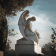 Kneeling marble guardian angel sculpture with folded wings, evoking peace, love, and eternal protection for memorial gardens, cemeteries, courtyards, and private sanctuaries.