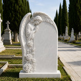 White marble tombstone with side praying angel stands on the green burial lawn.