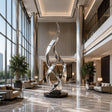 The tall twisted stainless steel sculpture stands in spacious double height luxury hotel lobby.