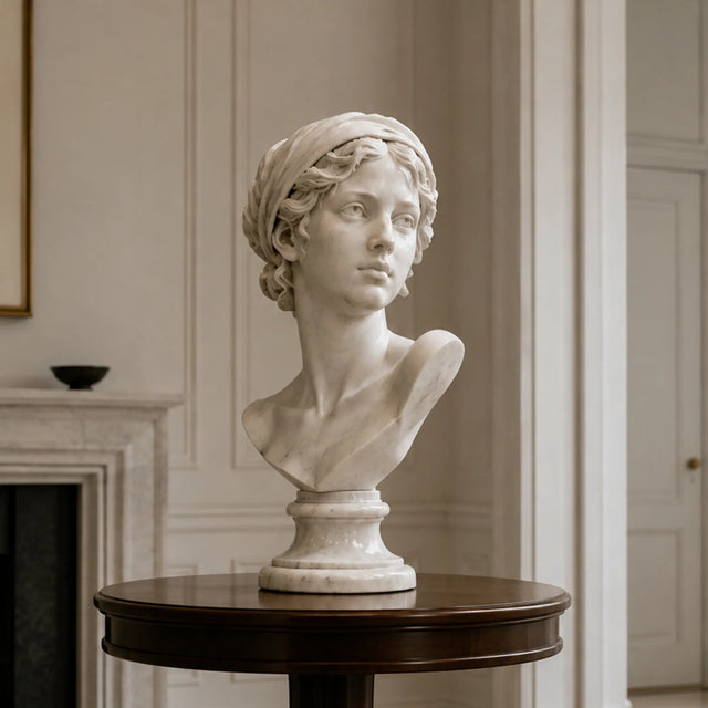 White marble female bust statue sits on a dark wooden round table in a living room.