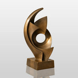 An abstract swirling bronze sculpture sits in a bright modern home.