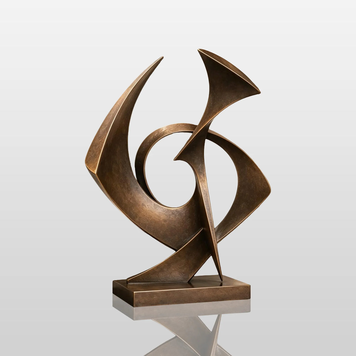 A bronze sculpture with intertwined shapes rests on a dark stone base inside a room.