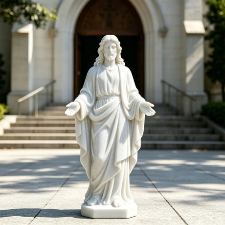 A white marble Jesus statue with open hands stands on the pavement in front of a church entrance.