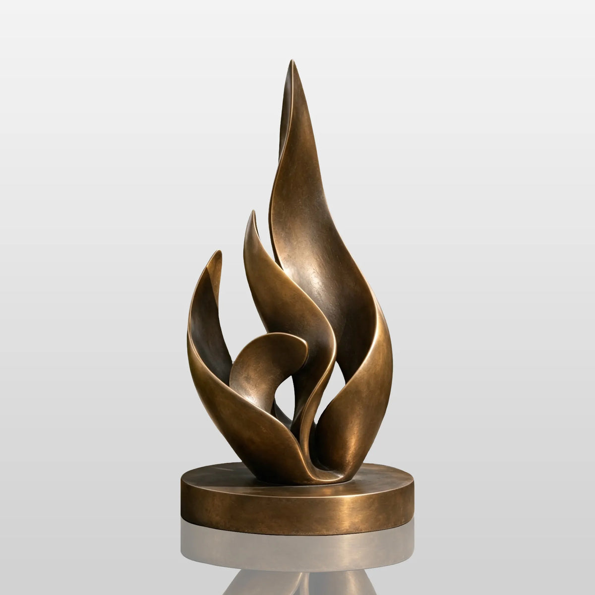 A bronze layered flame sculpture rests on stone walkway amid lush garden plants.