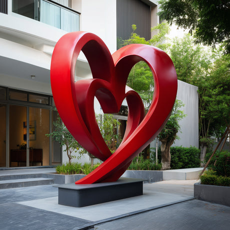 Large red heart sculpture installed in a modern courtyard
