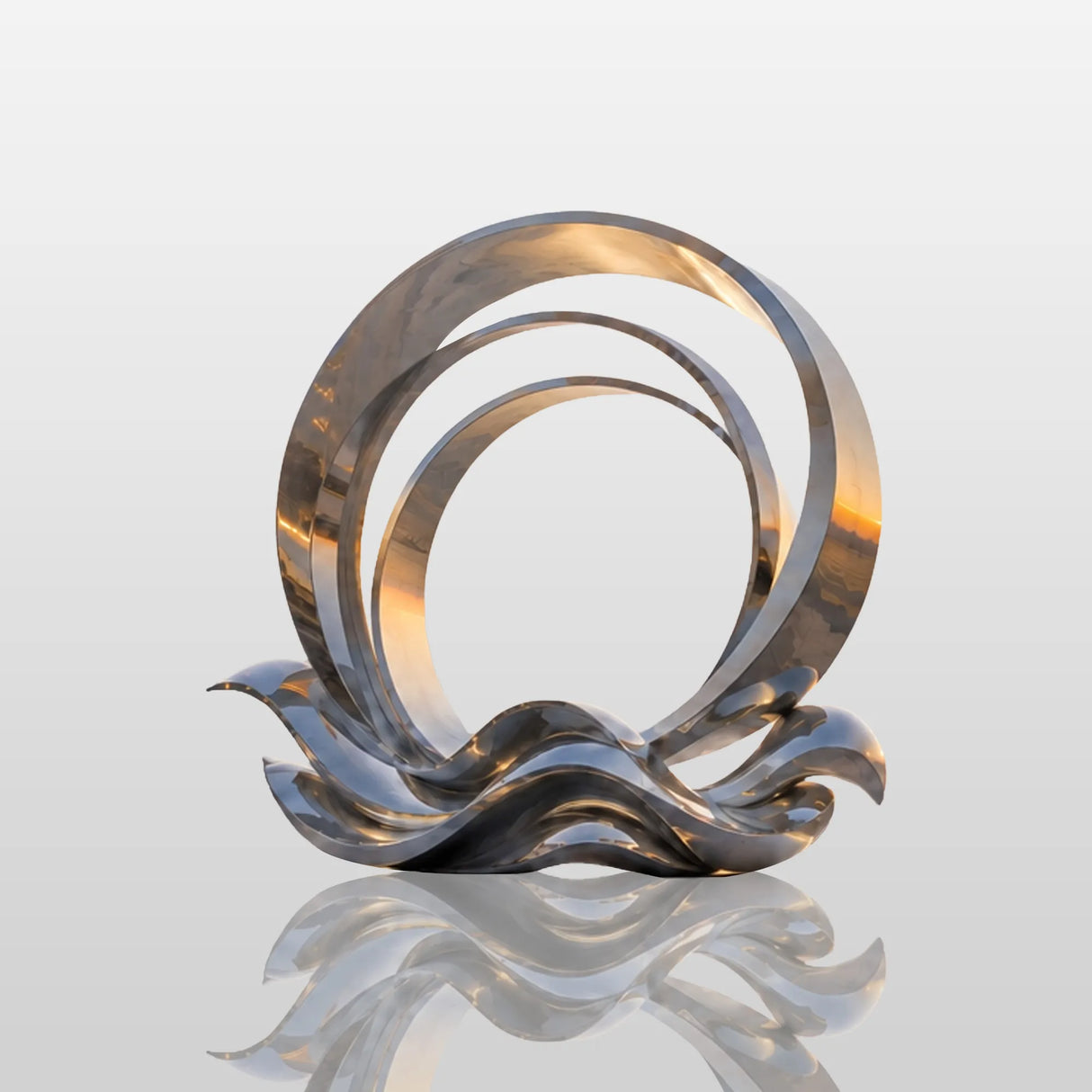The stainless steel ring wave sculpture stands on the seaside plaza at sunrise.