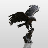 Dark bronze eagle statue perches on a stone pedestal near a home entrance.