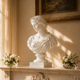 White marble flower crown lady bust stands on carved stone mantel.