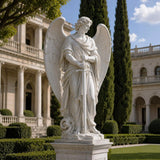 Marble Saint Michael statue stands in a garden with classical columned mansion and tall cypress trees behind.