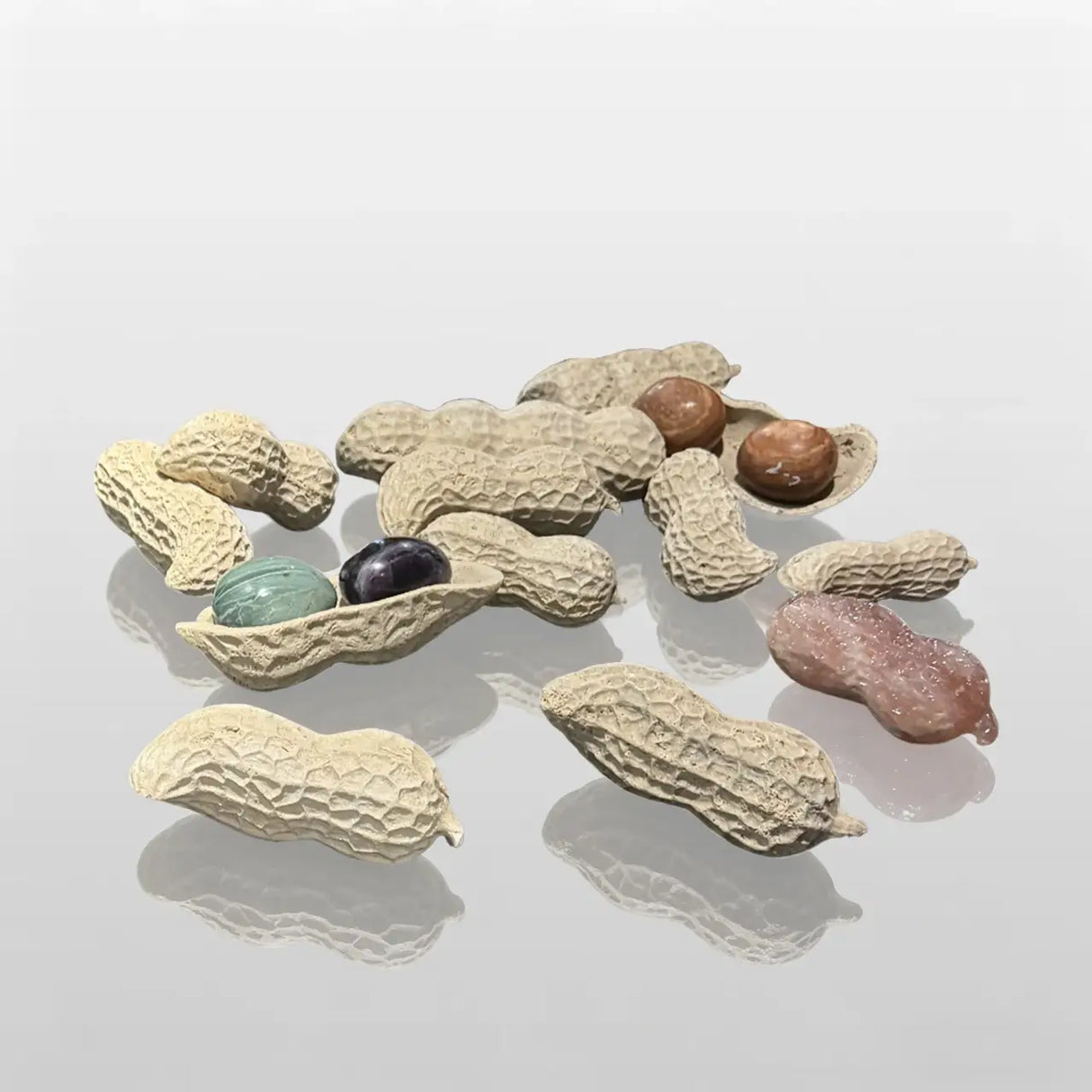 A group of abstract marble sculptures shaped like peanuts is displayed on a white pedestal.