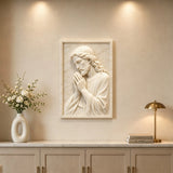 Marble relief of praying Jesus hangs on the wall in bright home interior.