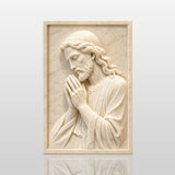 Marble relief of praying Jesus hangs on the wall in bright home interior.