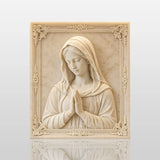 Marble Virgin Mary wall relief sculpture displayed on lit built in shelving indoors.