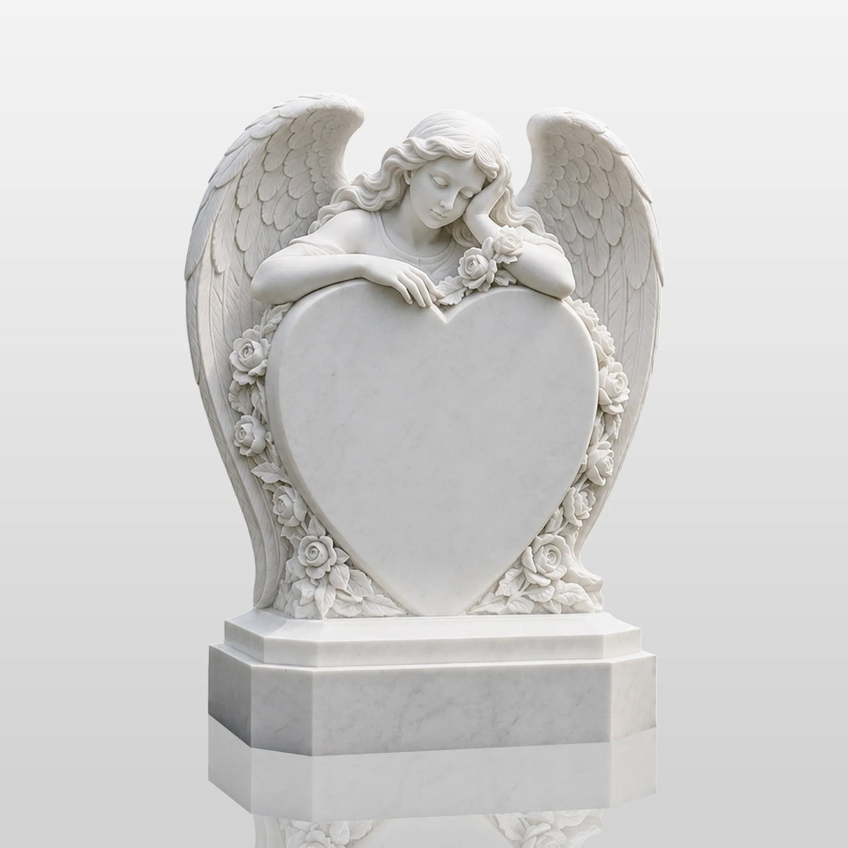 White marble tombstone carved with angel, roses and central blank heart stands on the black gravel cemetery ground.