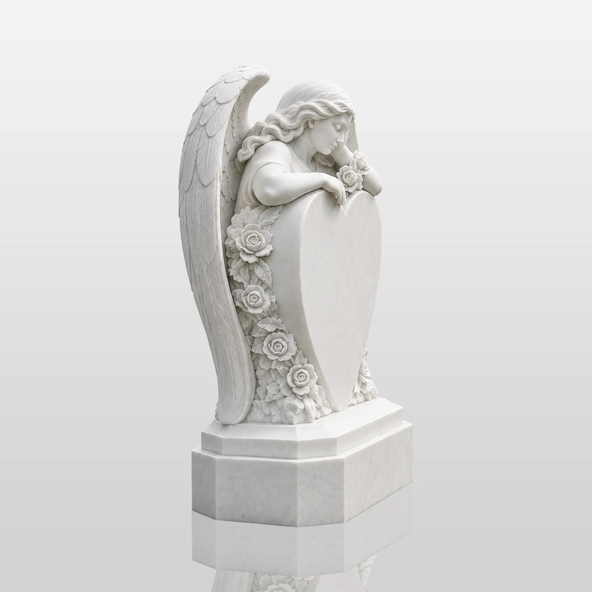 White marble tombstone carved with angel, roses and central blank heart stands on the black gravel cemetery ground.