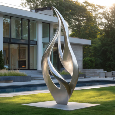 Stainless steel flame-shaped sculpture displayed in modern courtyard.