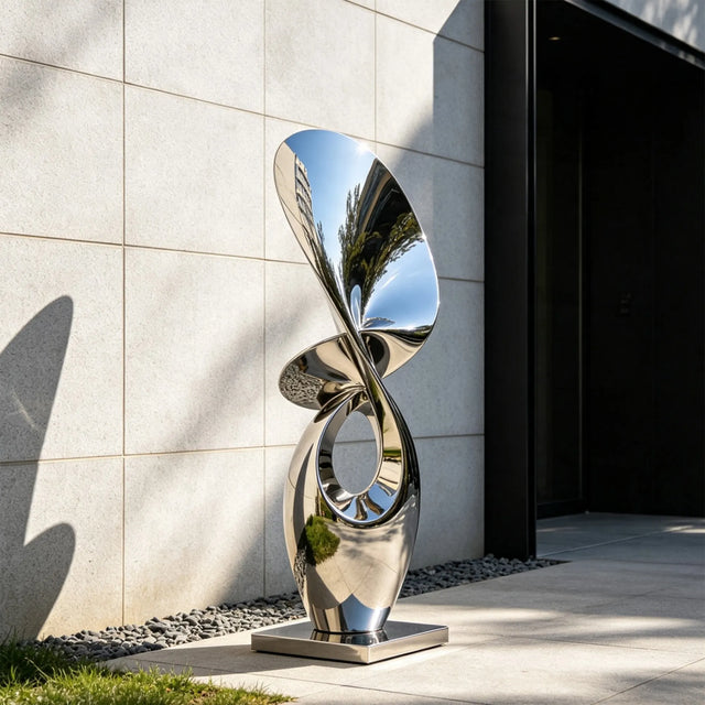 Abstract twist stainless steel sculpture stands outside a modern building.