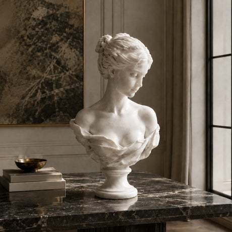 White marble female bust statue sits on a dark marble table in a refined indoor room.